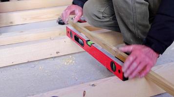 Installation of a wooden floor log on studs at the hydraulic level. Installation of the rough floor on the concrete floor of the house, repair of the house with your own hands, diy. Slow motion video