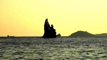 Seascape with a rock silhouette on the horizon. Beauty of nature video