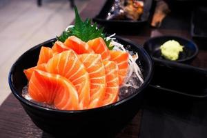 Sashimi salmon on the table in the restaurant light and dark. photo