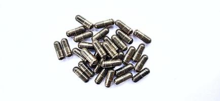 Herbal medicine black cumin capsules with negative space isolated on the gray white studio background. Nigella sativa. Suitable for promotion of health industry and company. photo