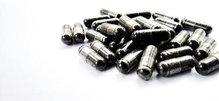 Herbal medicine black cumin capsules with negative space isolated on the gray white studio background. Nigella sativa. Suitable for promotion of health industry and company. photo