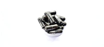 Herbal medicine black cumin capsules with negative space isolated on the gray white studio background. Nigella sativa. Suitable for promotion of health industry and company. photo