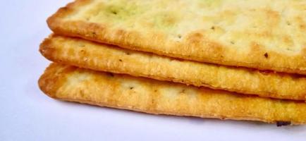 Sugarless and vegetable healthy cracker biscuit slices on the gray white studio background. Food background design. Suitable for promotion of food and beverage industry and company, food advertising. photo