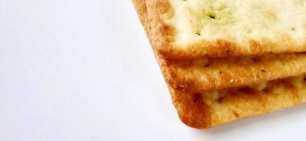 Sugarless and vegetable healthy cracker biscuit slices on the gray white studio background. Food background design. Suitable for promotion of food and beverage industry and company, food advertising. photo