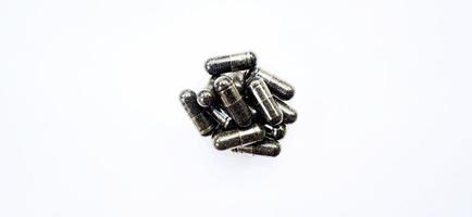 Herbal medicine black cumin capsules with negative space isolated on the gray white studio background. Nigella sativa. Suitable for promotion of health industry and company. photo