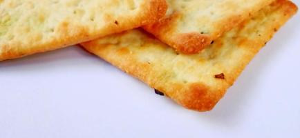 Sugarless and vegetable healthy cracker biscuit slices on the gray white studio background. Food background design. Suitable for promotion of food and beverage industry and company, food advertising. photo