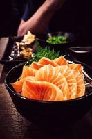 salmón sashimi en la mesa del restaurante claro y oscuro. foto