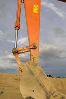 Excavators are stationary after work in the evening, using the arms of the car as a frame to see the beautiful sky and clouds of various colors in the evening, a beam of light into the beautiful river photo