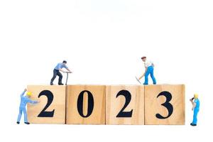 Miniature People Worker Team Create Number 2023 On Wooden Block photo