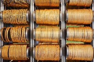 golden color bangles display for sale at local store , photo