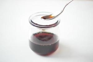 maple syrup in a small glass jar on table photo