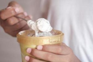 hombres jóvenes comiendo helado con sabor a vainilla en un recipiente foto