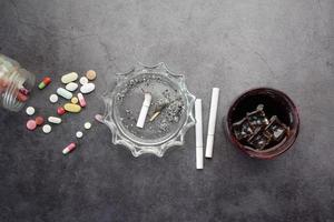 alcohol, pills and cigarette on table photo