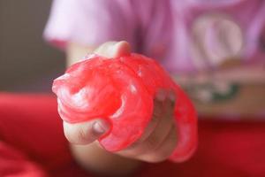 child Hand holding pink color slime photo