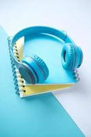 Audio book concept. Headphones and notepad on table photo