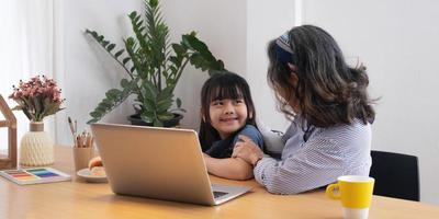 Asian grandmather teach granddaughter drawing and doing homework at home. photo