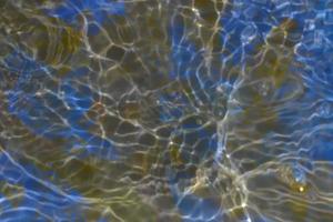 desenfoque de salpicaduras de agua de colores transparentes y borrosas. textura superficial de agua clara y tranquila con salpicaduras y burbujas. fondo de naturaleza abstracta de moda. ondas de agua a la luz del sol. foto