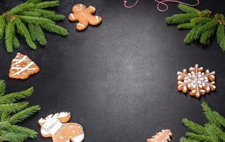 mesa navideña festiva con electrodomésticos, panes de jengibre, ramas de árboles y cítricos secos foto