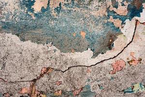 Texture of a concrete wall with cracks and scratches which can be used as a background photo