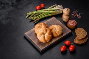 Crusty round bread rolls, known as Kaiser or Vienna rolls on a cutting board photo