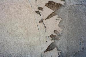 Texture of a concrete wall with cracks and scratches which can be used as a background photo