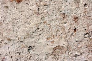 Texture of a concrete wall with cracks and scratches which can be used as a background photo