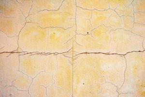 Texture of a concrete wall with cracks and scratches which can be used as a background photo