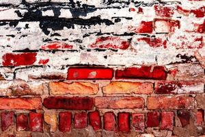 Texture of a brick wall with cracks and scratches which can be used as a background photo