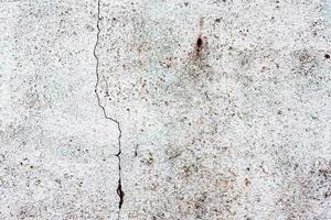 Texture of a concrete wall with cracks and scratches which can be used as a background photo