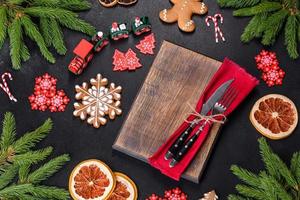 Festive Christmas table with appliances, gingerbreads, tree branches and dried citrus trees photo