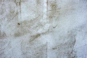 Texture of a concrete wall with cracks and scratches which can be used as a background photo