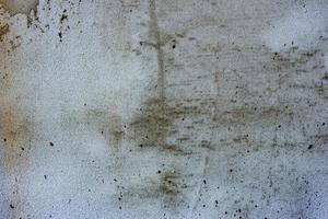 Texture of a concrete wall with cracks and scratches which can be used as a background photo