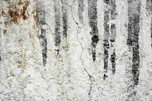 Texture of a concrete wall with cracks and scratches which can be used as a background photo