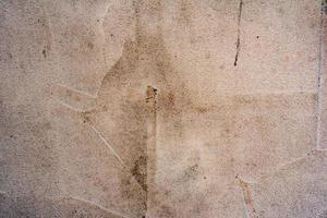 Texture of a concrete wall with cracks and scratches which can be used as a background photo