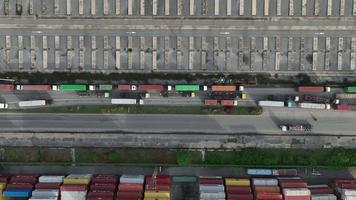 un camion de fret transporte un conteneur pour le chargement sur un cargo, de nombreux camions dans le concept de port de mer de dépôt logistique de terminal international concept de transport et de service d'expédition de fret. video