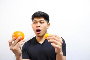 Attractive asian man eating oranges. Isolated on white background photo