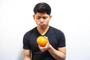 Attractive asian man eating oranges. Isolated on white background photo