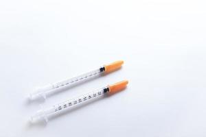 un par de jeringas de insulina sobre fondo blanco. foto