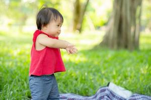 Portrait face of cute asian little girl and child happiness and fun in the park in the summer, smile and happy from asia kid and relax in the garden, lifestyle childhood concept. photo