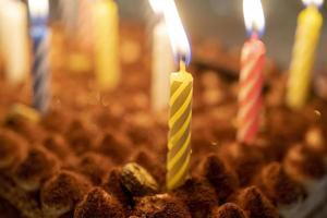 Festive background with burning candles on the surface of the cake photo