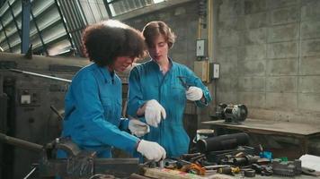Two professional female industry workers in safety uniforms and engineers' partners worked with metalwork tools, mechanical lathe machines, and spare parts workshop in the steel manufacturing factory. video