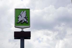 A network of gas stations in Ukraine with an OKKO store and cafe. Logo against a blue sky with clouds. Filling station, retail trade in petroleum products. Ukraine, Kyiv - May 23, 2022. photo