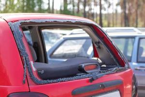 A car after an accident with a broken rear window. Broken window in a vehicle. The wreckage of the interior of a modern car after an accident, a detailed close-up view of the damaged car. photo