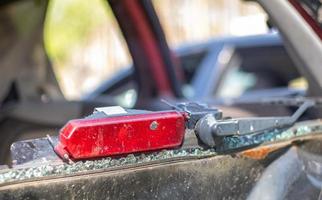 A car after an accident with a broken rear window. Broken window in a vehicle with a rear brake light. Interior wreckage, detailed close-up view of a damaged modern car. photo