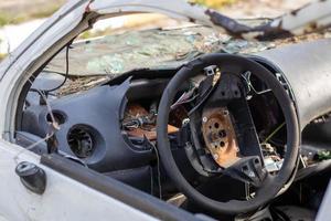 Close-up of the steering wheel of a car after the accident. No driver airbag. The steering wheel of a car after being shot from an airbag close-up. Broken windshield with steering wheel. photo