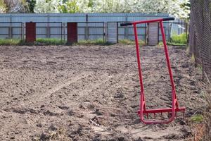 pala roja en forma de tenedor en el jardín. pala milagrosa, herramienta práctica. cultivador manual. el cultivador es una herramienta eficaz para la labranza. aflojamiento de la cama. herramientas agrícolas sostenibles. foto