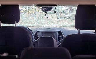 ventana de coche dañada después de un accidente. parabrisas roto como resultado de un accidente, vista interior. detalles del interior de la cabina, vista desde la cabina. movimiento seguro. parabrisas roto. grietas y daños en el vidrio. foto