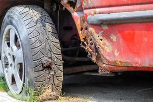 Flat car tire close-up. Shot through the wheel by the police while chasing a lawbreaker. Bullet hole in a wheel tire close-up. Tires with lead bullets stuck in them. The tire needs to be replaced. photo