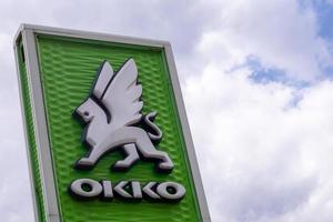 A network of gas stations in Ukraine with an OKKO store and cafe. Logo against a blue sky with clouds. Filling station, retail trade in petroleum products. Ukraine, Kyiv - May 23, 2022. photo