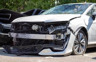 Many broken cars after a traffic accident in the parking lot of a restoration service station on the street. Car body damage workshop outdoors. Sale of insurance emergency vehicles at auction. photo